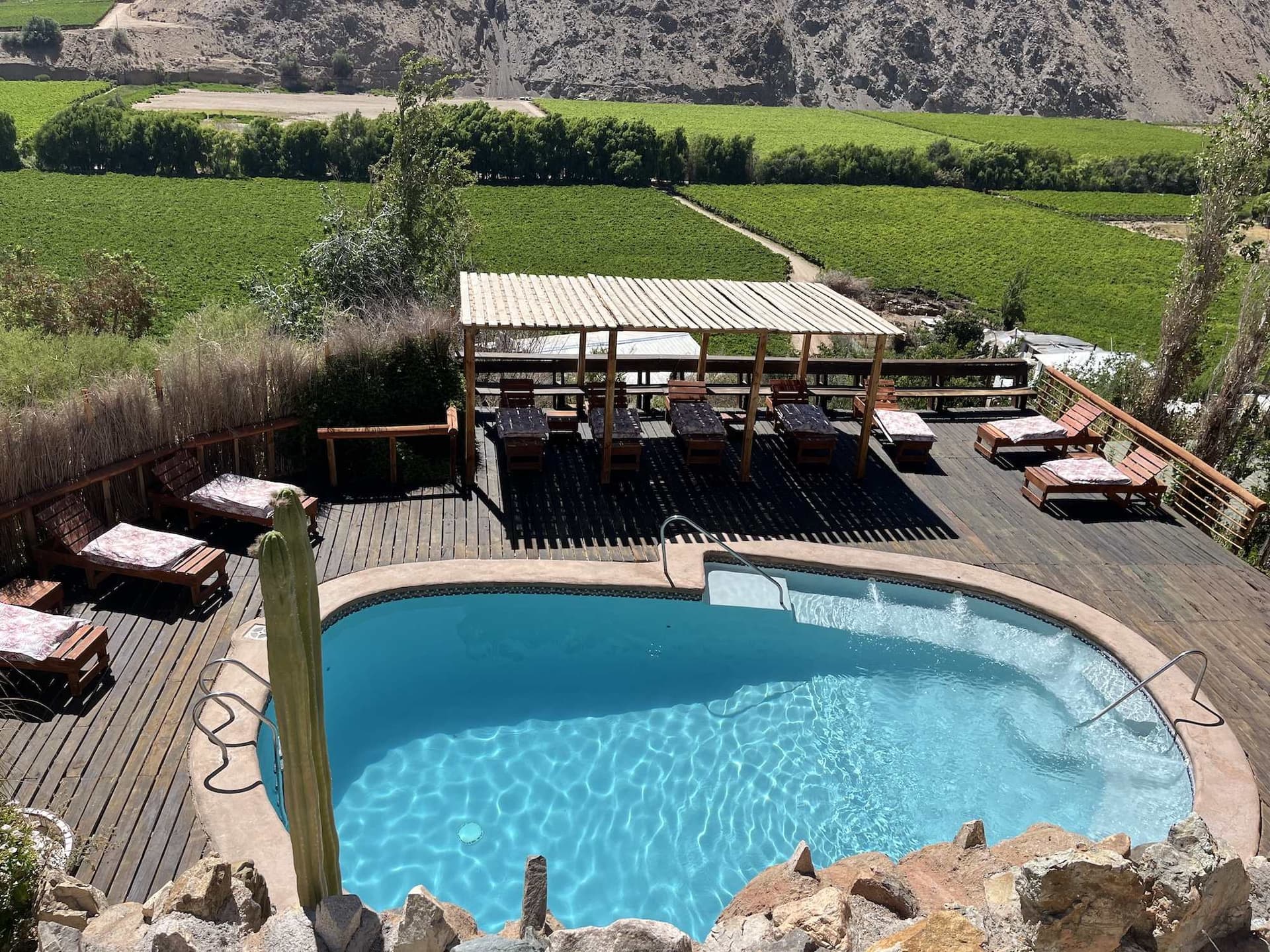 Salt-water pool at Cabañas Elquimista with the Elqui Valley and its hills behind